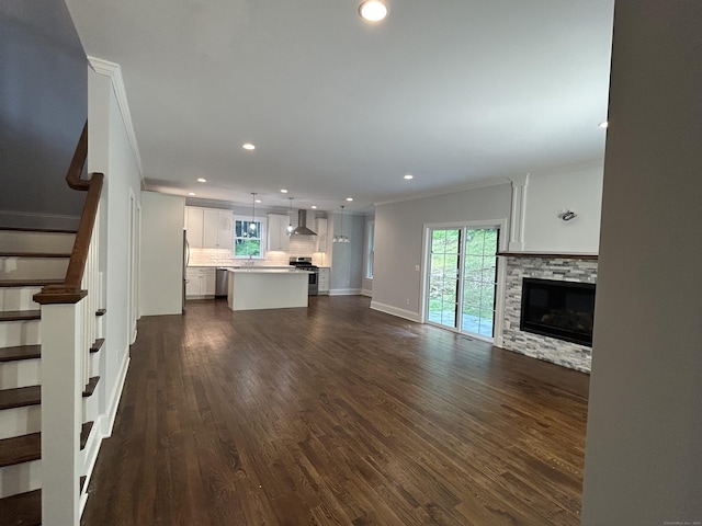 42 Long River Rd, Sherman, CT 06784 - unfurnished living room featuring crown molding, recessed lighting, stairway, dark wood-style flooring, and a stone fireplace