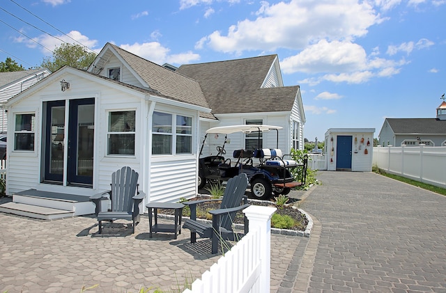 96 Chalker Beach Rd, Old Saybrook, CT 06475 - view of front of house featuring a shingled roof, an outdoor structure, and entry steps