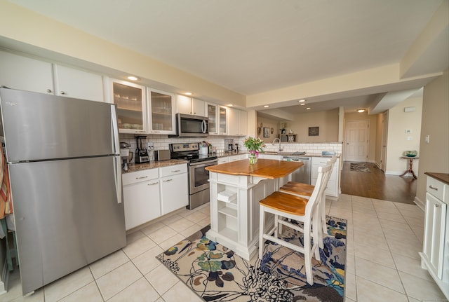 170 Turtle Bay Dr Unit 170, Branford, CT 06405 - kitchen featuring stainless steel appliances, light tile patterned flooring, a peninsula, backsplash, and recessed lighting
