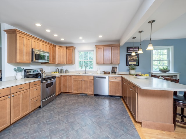 109 Westport Rd, Wilton, CT 06897 - kitchen featuring stainless steel appliances, a peninsula, a kitchen bar, healthy amount of natural light, and recessed lighting