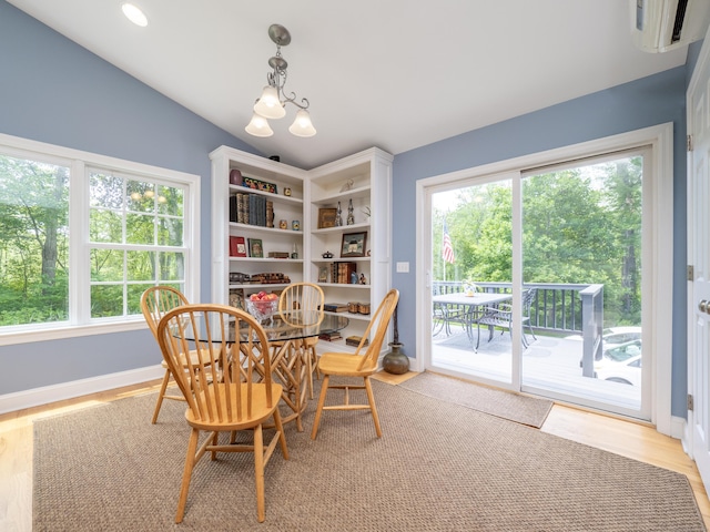 109 Westport Rd, Wilton, CT 06897 - dining space with vaulted ceiling, a wall unit AC, light wood-style flooring, and a chandelier