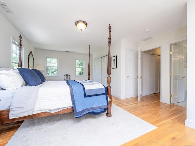 109 Westport Rd, Wilton, CT 06897 - bedroom with light wood-style floors, multiple windows, and two closets