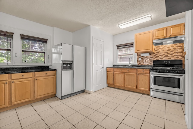 314 Judson Pl, Bridgeport, CT 06610 - kitchen with white refrigerator with ice dispenser, stainless steel gas range oven, under cabinet range hood, a textured ceiling, and healthy amount of natural light