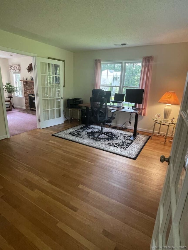 475 Niederwerfer Rd, South Windsor, CT 06074 - home office with wood finished floors, a textured ceiling, and a fireplace