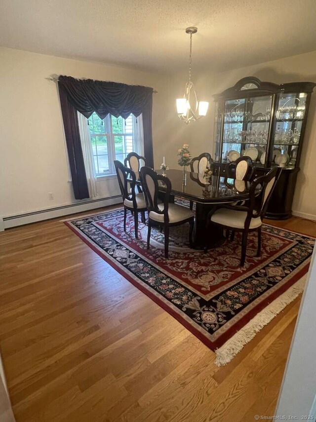 475 Niederwerfer Rd, South Windsor, CT 06074 - dining room with a baseboard radiator, wood finished floors, a textured ceiling, and a chandelier