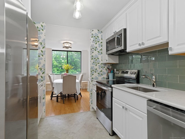 155 Brewster St Apt 3K, Bridgeport, CT 06605 - kitchen with appliances with stainless steel finishes, white cabinetry, light countertops, and backsplash