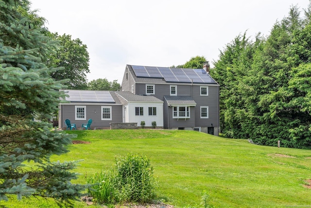 114 Boulter Rd, Wethersfield, CT 06109 - rear view of property featuring roof mounted solar panels, a yard, a chimney, and a shingled roof