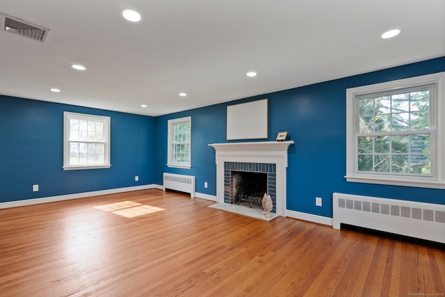 114 Boulter Rd, Wethersfield, CT 06109 - unfurnished living room featuring radiator, wood finished floors, a brick fireplace, and recessed lighting