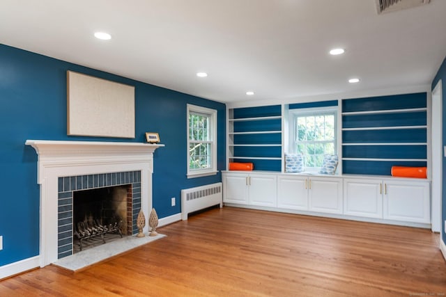 114 Boulter Rd, Wethersfield, CT 06109 - unfurnished living room featuring radiator, light wood-style floors, recessed lighting, a fireplace, and built in shelves