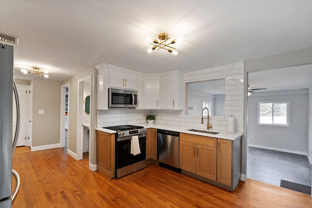 114 Boulter Rd, Wethersfield, CT 06109 - kitchen with appliances with stainless steel finishes, a chandelier, light countertops, and decorative backsplash