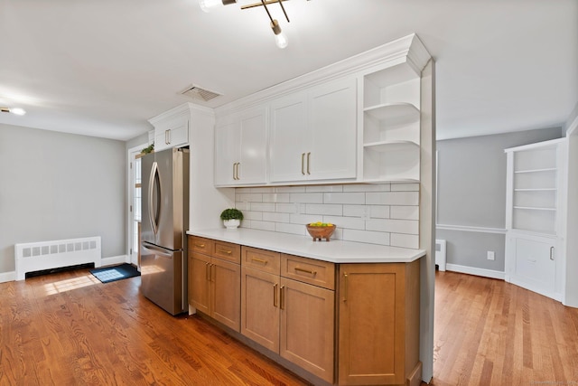 114 Boulter Rd, Wethersfield, CT 06109 - kitchen featuring radiator heating unit, freestanding refrigerator, open shelves, light countertops, and light wood-style floors