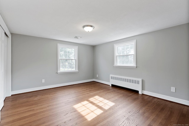 114 Boulter Rd, Wethersfield, CT 06109 - unfurnished room featuring radiator heating unit, plenty of natural light, and wood finished floors