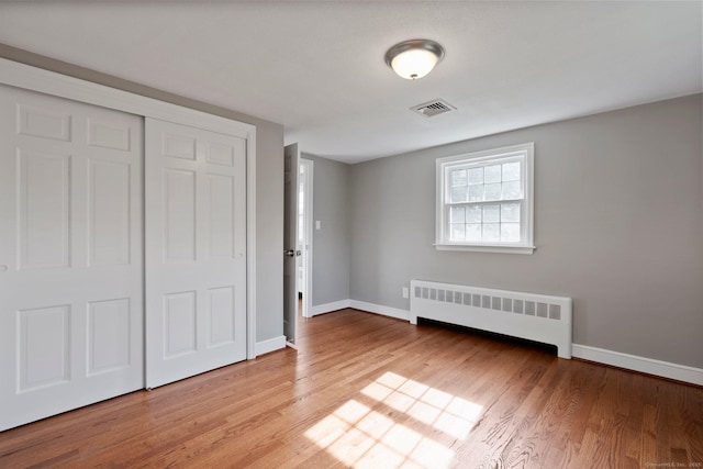 114 Boulter Rd, Wethersfield, CT 06109 - unfurnished bedroom with radiator heating unit, wood finished floors, and a closet