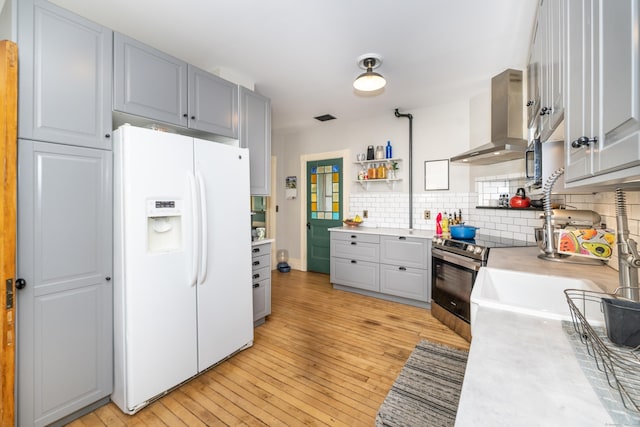 45 Harris Fuller Rd, Preston, CT 06365 - kitchen with white fridge with ice dispenser, wall chimney exhaust hood, stainless steel range with electric stovetop, light countertops, and light wood finished floors
