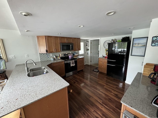 34 Park St, Griswold, CT 06351 - kitchen featuring appliances with stainless steel finishes, a peninsula, dark wood-style flooring, backsplash, and light stone counters