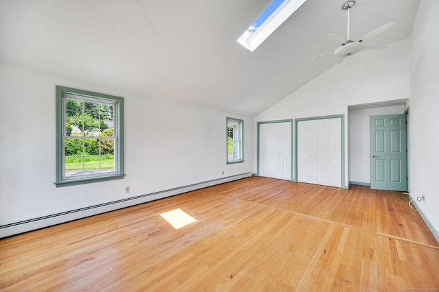 442 Merrow Rd, Tolland, CT 06084 - unfurnished bedroom with multiple closets, a baseboard heating unit, high vaulted ceiling, wood finished floors, and a skylight
