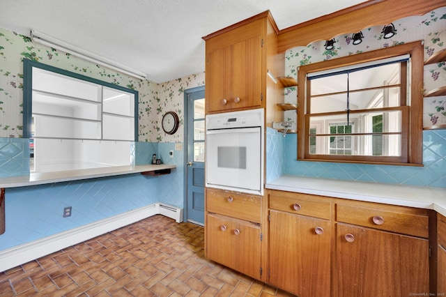 442 Merrow Rd, Tolland, CT 06084 - kitchen with white oven, wallpapered walls, open shelves, light countertops, and brown cabinetry