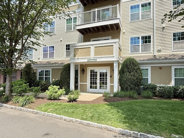 34 Schoolhouse Dr Unit 405, West Hartford, CT 06110 - property entrance featuring french doors, stucco siding, and a lawn