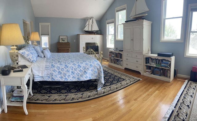 42 Bluff St, Westbrook, CT 06498 - bedroom featuring lofted ceiling, wood finished floors, and a tile fireplace