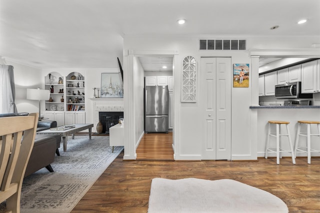 32 Glenview Dr Unit 32, Cromwell, CT 06416 - kitchen with appliances with stainless steel finishes, white cabinetry, crown molding, built in features, and dark wood-type flooring