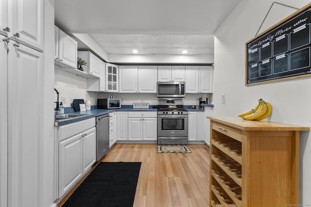 32 Glenview Dr Unit 32, Cromwell, CT 06416 - kitchen featuring appliances with stainless steel finishes, light wood finished floors, white cabinets, glass insert cabinets, and recessed lighting
