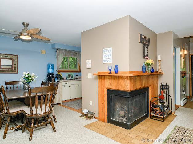 172 Old Farms Rd Unit 172, Torrington, CT 06790 - dining room featuring a multi sided fireplace, a ceiling fan, and baseboard heating