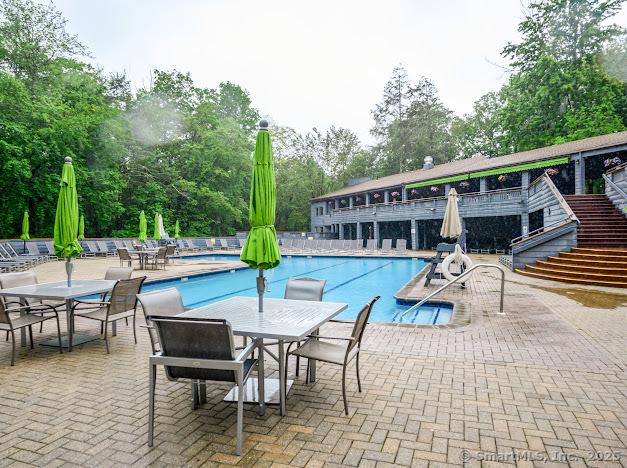 172 Old Farms Rd Unit 172, Torrington, CT 06790 - community pool featuring view of wooded area, a patio, outdoor dining space, and stairway