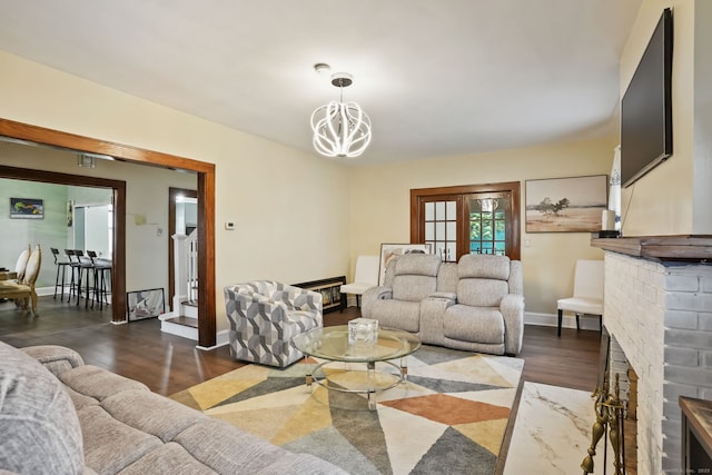 73 Atwater St, Bridgeport, CT 06604 - living room featuring dark wood-type flooring, a chandelier, and a brick fireplace