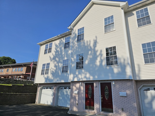 26 Roger Ave, Danbury, CT 06810 - townhome / multi-family property featuring an attached garage, brick siding, and asphalt driveway