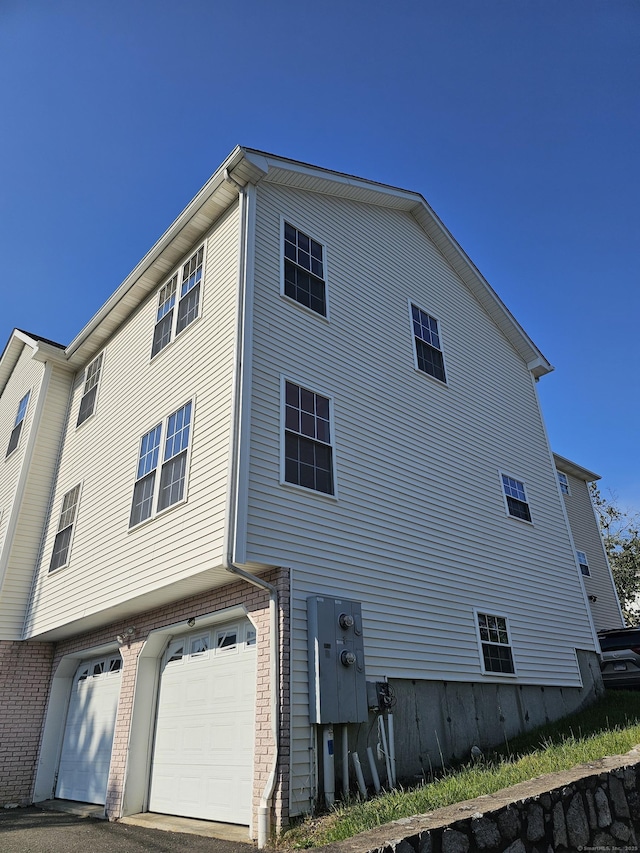 26 Roger Ave, Danbury, CT 06810 - view of side of home with a garage and brick siding