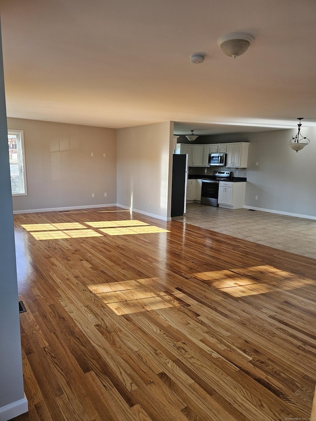 26 Roger Ave, Danbury, CT 06810 - unfurnished living room with wood finished floors and baseboards