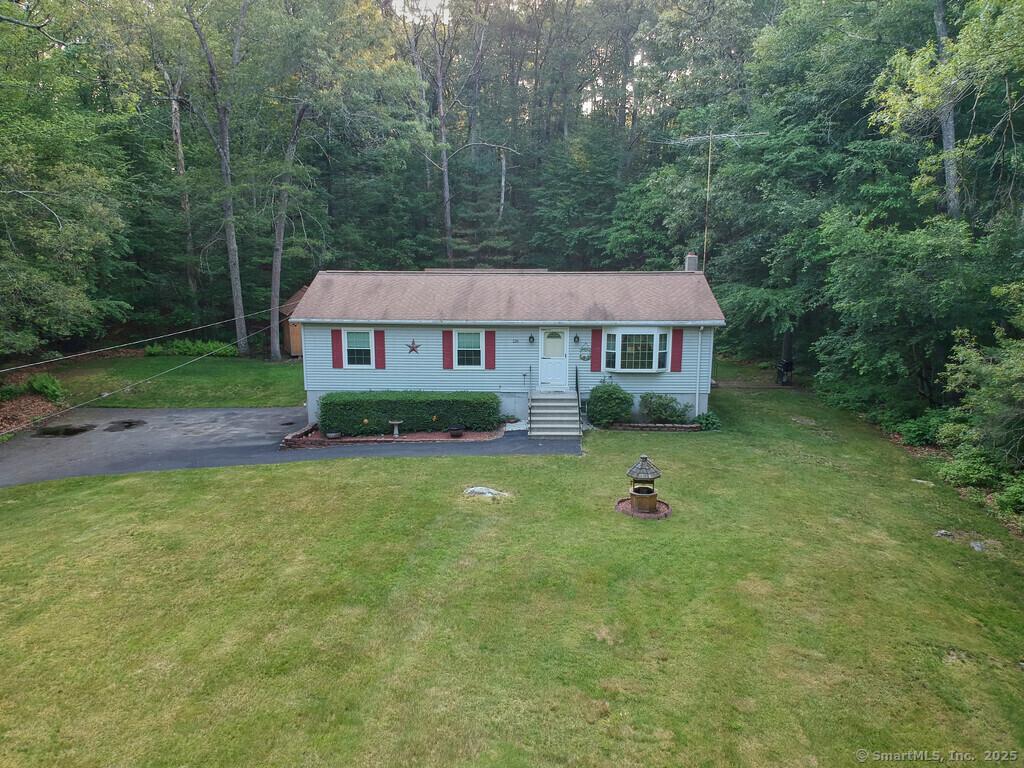 126 Labby Rd, Thompson, CT 06255 - view of front facade featuring a wooded view, a front lawn, and a chimney
