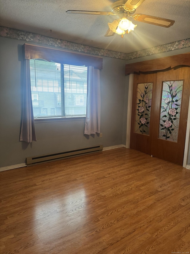260 Scott Rd Apt 1, Waterbury, CT 06705 - empty room with a baseboard radiator, wood finished floors, a ceiling fan, and a textured ceiling
