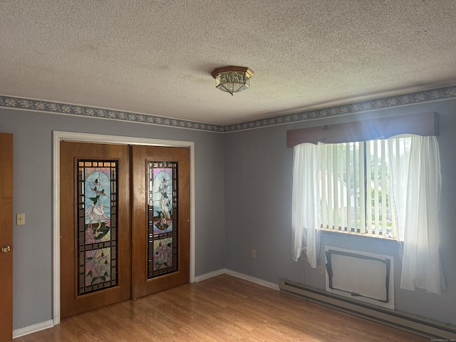 260 Scott Rd Apt 1, Waterbury, CT 06705 - unfurnished room featuring a baseboard heating unit, wood finished floors, and a textured ceiling