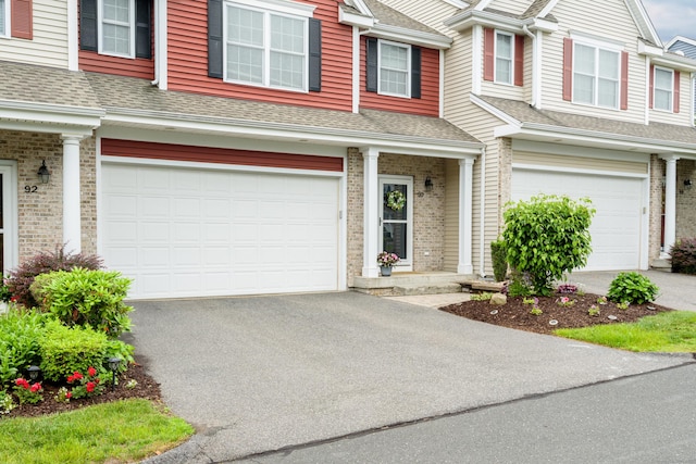 90 Bridlewood Ln Unit 90, Vernon, CT 06066 - view of property with an attached garage, asphalt driveway, a shingled roof, and brick siding