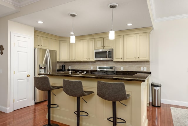 90 Bridlewood Ln Unit 90, Vernon, CT 06066 - kitchen with appliances with stainless steel finishes, cream cabinetry, tasteful backsplash, wood finished floors, and recessed lighting