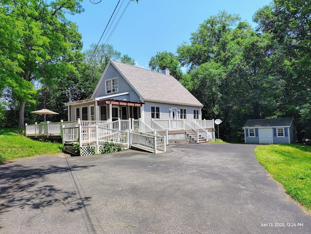 43 Rte 87, Columbia, CT 06237 - view of front of house with a wooden deck, an outdoor structure, a chimney, asphalt driveway, and a shingled roof