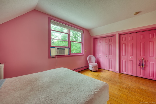 43 Rte 87, Columbia, CT 06237 - bedroom with vaulted ceiling, multiple closets, cooling unit, a baseboard heating unit, and light wood-style flooring
