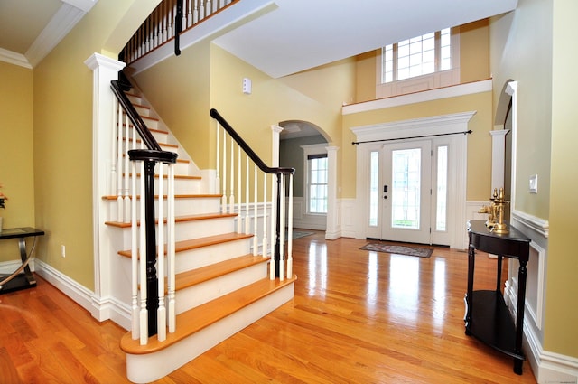 1 Leghorn Ln, Cromwell, CT 06416 - foyer featuring arched walkways, a wainscoted wall, wood finished floors, stairway, and plenty of natural light