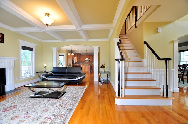 1 Leghorn Ln, Cromwell, CT 06416 - living area featuring decorative columns, healthy amount of natural light, light wood finished floors, ornamental molding, and beamed ceiling
