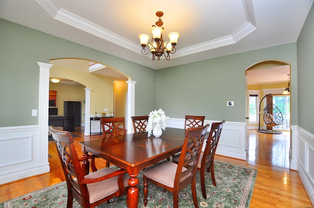 1 Leghorn Ln, Cromwell, CT 06416 - dining area with arched walkways, a tray ceiling, ornamental molding, wainscoting, and light wood-style floors