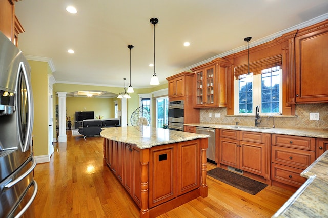 1 Leghorn Ln, Cromwell, CT 06416 - kitchen with ornate columns, stainless steel appliances, light wood finished floors, a kitchen island, and brown cabinets