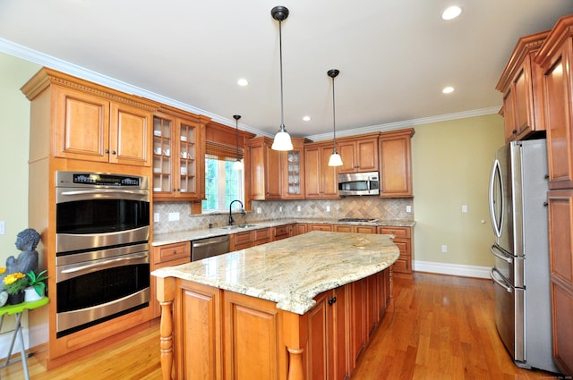 1 Leghorn Ln, Cromwell, CT 06416 - kitchen with appliances with stainless steel finishes, a center island, brown cabinetry, ornamental molding, and backsplash