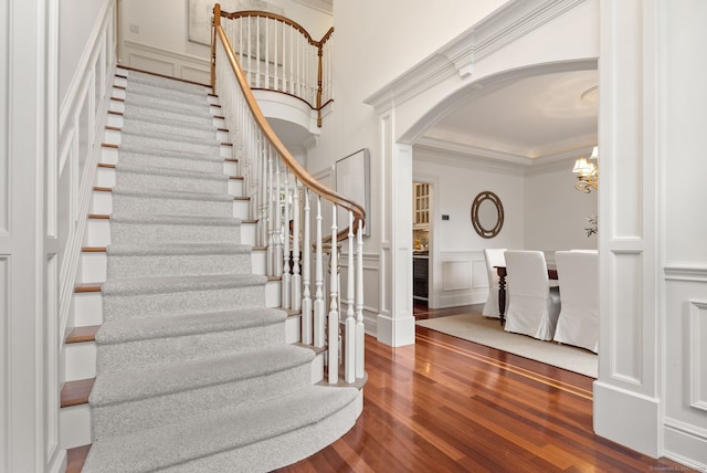 43 Chessor Ln, Wilton, CT 06897 - entryway with a decorative wall, wood finished floors, stairs, arched walkways, and a chandelier