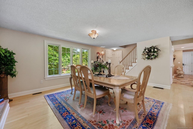 67 Hayden Hill Rd, Haddam, CT 06438 - dining room featuring stairs, light wood-style floors, and a textured ceiling
