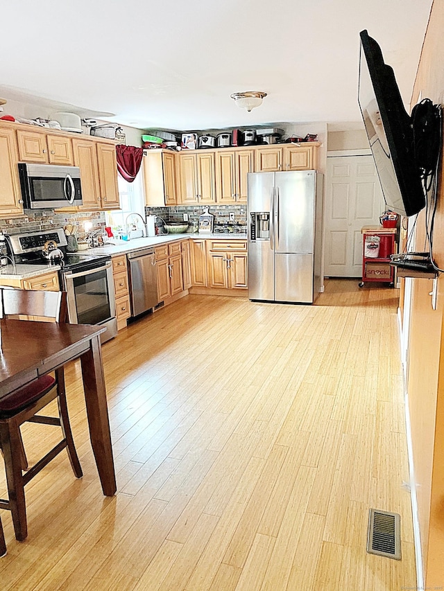 13 Sherman St, Norwich, CT 06360 - kitchen with appliances with stainless steel finishes, light brown cabinets, light wood-type flooring, and backsplash