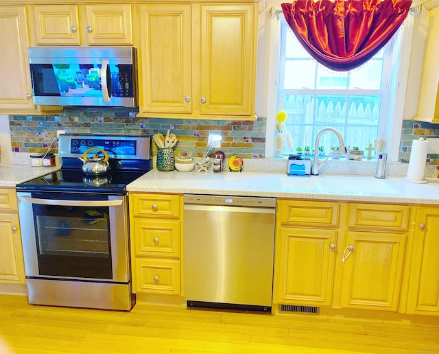 13 Sherman St, Norwich, CT 06360 - kitchen featuring stainless steel appliances, backsplash, light countertops, and light wood-type flooring