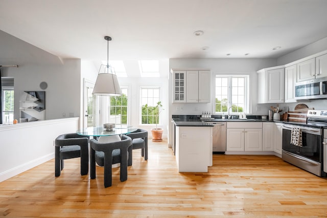 557 Upper Grassy Hill Rd, Woodbury, CT 06798 - kitchen featuring stainless steel appliances, dark countertops, light wood finished floors, glass insert cabinets, and recessed lighting