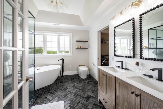 557 Upper Grassy Hill Rd, Woodbury, CT 06798 - bathroom featuring washer / clothes dryer, a freestanding bath, double vanity, and a chandelier