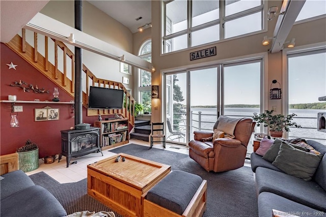 166 Old Colchester Rd, Salem, CT 06420 - living room featuring a wood stove, a towering ceiling, stairway, and tile patterned flooring